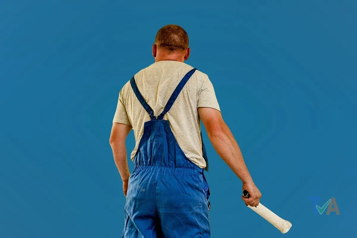 Professional painter painting interior wall with roller in Australian home